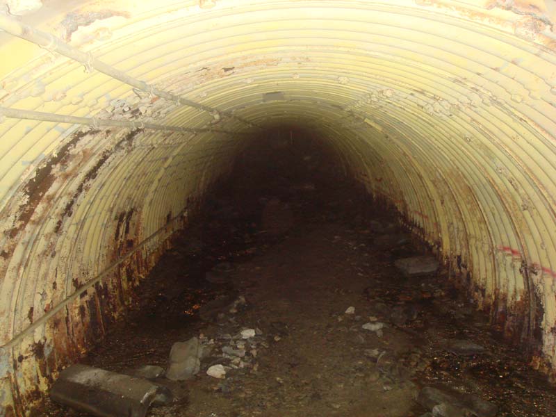 Closer to the blast locks, the tunnel becomes increasingly low as silt and rock fills the bottom of the passage.  Just ahead, the tunnel is blocked by heavy steel to prevent intrusion.