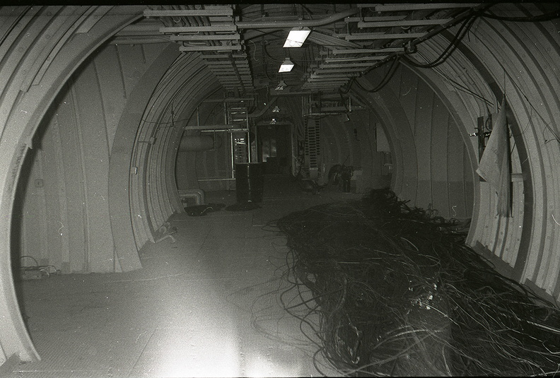Unknown squadron and site undergoing salvage operations. Presumed to be taken in the early 1970's, this photo shows cabling removed for salvage in the main tunnel junction (T.J.#10) laying on the deck in front of the raw water tanks (not visible). View is looking toward the doorway of the control center. Entry portal is at the first left and ahead are the tunnels leading to the antenna silos (at left) and launchers (at right). Please contact me at chromehooves@hotmail.com if you have any information on this photo. Any help identifying this or any other photos in the archive is greatly appreciated. Taken: Unknown-- probably late 1960's to early 1970's. Source: provided courtesy of the Titan Missile Museum/Nick Halliday (http://www.titanmissilemuseum.org/) titan_hall-way_cable-1.jpg
