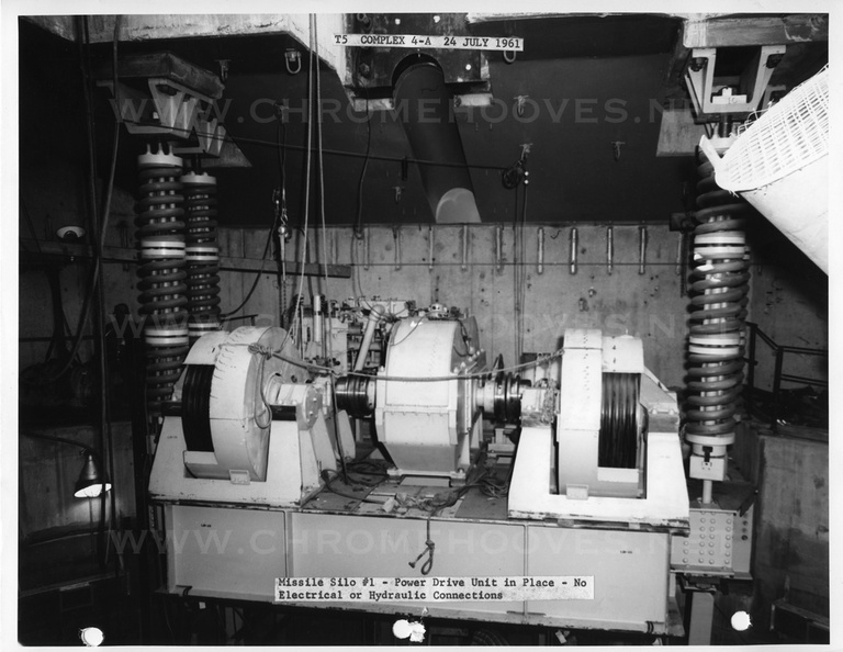 Construction at Beale 851-A, silo #1 showing the launcher elevator motor and platform suspended by its four enormous spring assemblies at the catwalk level. Note that the wire ropes for the elevator and the hydraulic rams for the silo doors are not yet installed. This is the system that raised and lowered the missile for launch or for storage in hard condition. Taken: July 24, 1961. Source: Martin Co. titan_group002-1.jpg