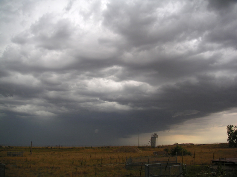 Stormy skies over Lowry 724-C. Taken near the entry portal looking north toward launcher #2 and a tower made from one of the missile platform flame deflectors and salvaged items from inside the complex. Covered air shafts are in the foreground at right. Taken: August 3, 2005. Source: Myself pict0097.jpg